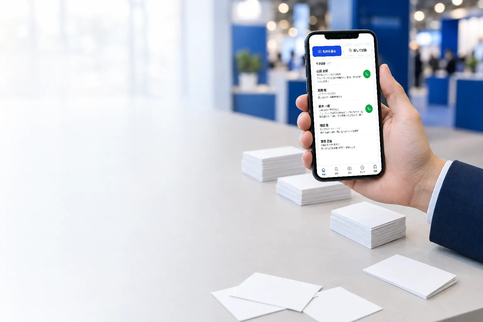 名刺の束のそばで、スマートフォンに masc-harness の画面を表示している手元